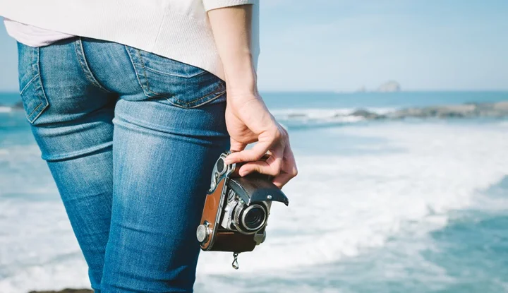 Female photographer holding vintage camera on travel