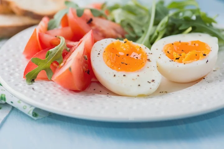 Breakfast with soft-boiled egg, arugula and tomatoes