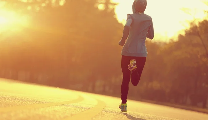 young fitness woman runner athlete running at sunrise road