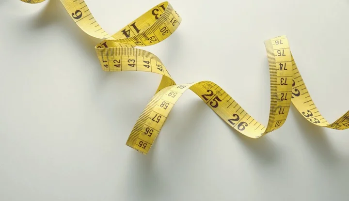 Yellow tape measure in meters and inches in a spiral