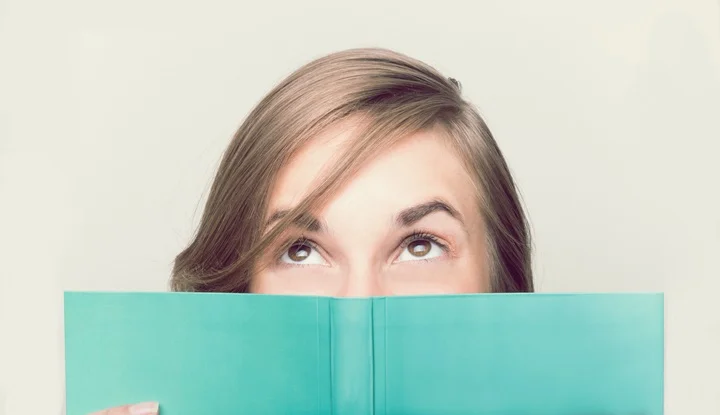 An isolated shot of a beautiful woman reading a book